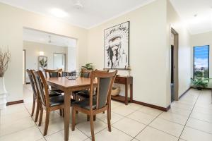 uma sala de jantar com mesa e cadeiras em Huge CBD Top Floor Apartment with Breath Taking Views! em Darwin