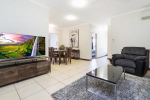 sala de estar con TV de pantalla plana y sofá en Huge CBD Top Floor Apartment with Breath Taking Views! en Darwin