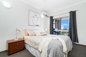 Habitación blanca con cama y ventana en Huge CBD Top Floor Apartment with Breath Taking Views!, en Darwin