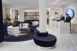 a lobby with a bar with people standing at a counter at Hôtel Bel Ami in Paris