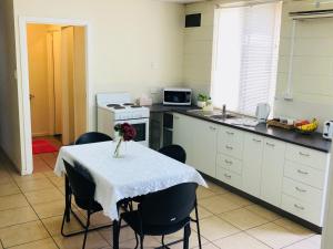 una cocina con una mesa con un jarrón de flores. en Accommodation @ Isa, en Mount Isa