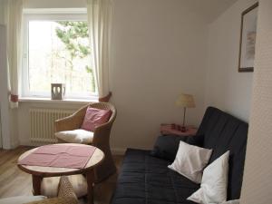 a living room with a couch and a table and a window at Landhaus Dr. Seiffert in Scharbeutz