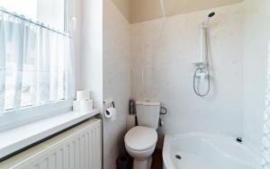 カルパチにあるApartamenty EverySky - Kolejowa 4の白いバスルーム(トイレ、シャワー付)