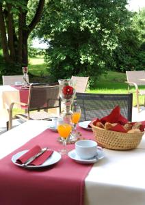 uma mesa com uma toalha de mesa rosa e uma mesa com um cesto de comida em Landgasthof Karolinenhöhe em Lichtenfels
