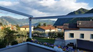 uma varanda com vista para uma cidade e para as montanhas em Appartamento Clivo em Solto Collina