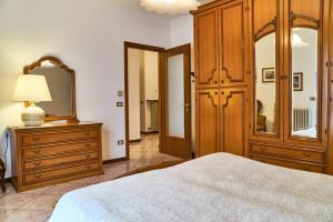 um quarto com uma cama, uma cómoda e um espelho em Appartamento Clivo em Solto Collina