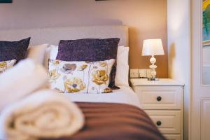 1 dormitorio con 1 cama y mesita de noche con lámpara en Ferlas Bed and Breakfast en Penrhyndeudreath