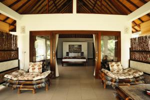 uma sala com um quarto com uma cama e cadeiras em Bali Dream House em Amed