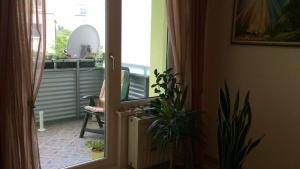 Une porte ouverte s'ouvre sur un balcon avec une plante. dans l'établissement Private rooms IN WIEN, à Vienne