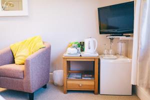 a living room with a chair and a tv at Ferlas Bed and Breakfast in Penrhyndeudreath
