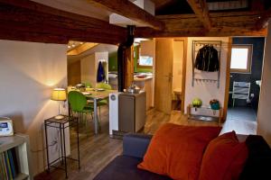 ein Wohnzimmer mit einem Sofa und einer Küche in der Unterkunft Appartement sous les combles - Chalet La Biolle - Vercorin in Vercorin