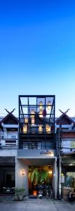 a building with a balcony on top of it at Pak Ping The Cozy Living in Chiangmai in Chiang Mai