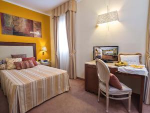 ein Schlafzimmer mit einem Bett, einem Schreibtisch und einem Stuhl in der Unterkunft Hotel For You in Olbia