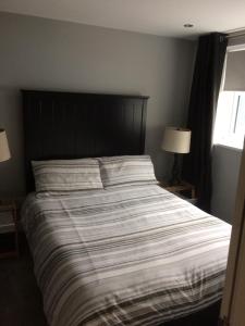 a bedroom with a large bed with a striped comforter at Stafford apartments in Stafford