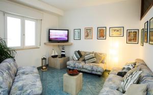 a living room with two couches and a flat screen tv at Hotel Giulietta in Senigallia