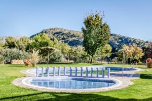 a swimming pool in a park with a fence around it at Hotel Rural Los Nogales in Pozo Alcón