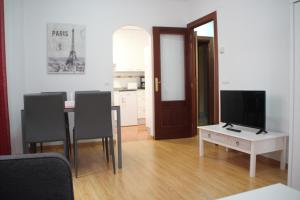 a living room with a table and chairs and a television at Apartamentos San Lázaro in Ezcaray