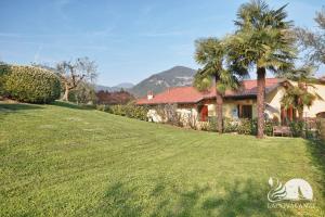 a house with palm trees in front of a yard at Appartamento il Moresine in Roe