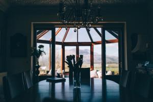 a dining room table with a vase of flowers on it at Ferlas Bed and Breakfast in Penrhyndeudreath