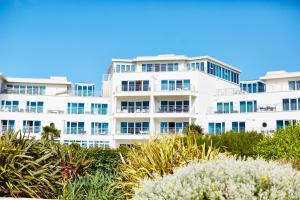 a white building with blue windows and plants at St Moritz Hotel and Cowshed Spa in Polzeath