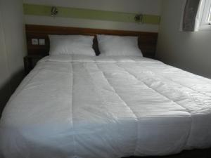 1 cama blanca grande con sábanas y almohadas blancas en Mareva37, en Trogues