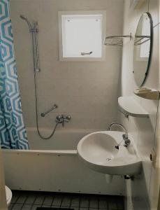 uma casa de banho com um lavatório, um chuveiro e uma banheira em Zeebries in De Kaap 4 p em Hollum