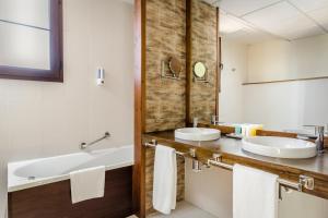 a bathroom with two sinks and a large mirror at Hotel Rural Los Nogales in Pozo Alcón