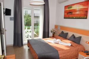 a bedroom with a bed with two towels on it at Hotel Verdi in Lido di Jesolo +124 photos
