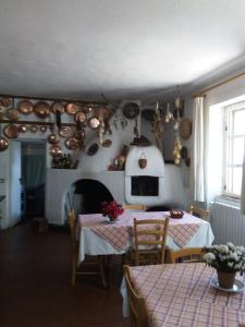 uma cozinha com duas mesas e panelas e frigideiras na parede em Agriturismo Costiolu em Nuoro