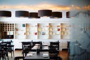 a dining room with tables and chairs and shelves at St Moritz Hotel and Cowshed Spa in Polzeath