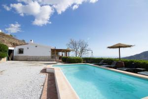 a swimming pool in front of a house at Holiday House ¨Montepiscina¨ in Cómpeta