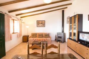 a living room with a couch and a tv at Holiday House ¨Montepiscina¨ in Cómpeta