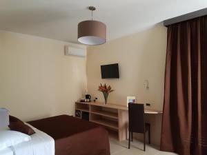 ein Hotelzimmer mit einem Schreibtisch und einem Bett in der Unterkunft B&B Villa Valentina in Taormina