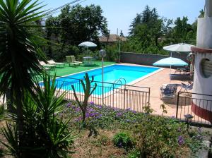 una piscina con sillas y sombrillas en un patio en Al Villino Sunshine in villa con piscina ed idromassaggio en SantʼAlfio
