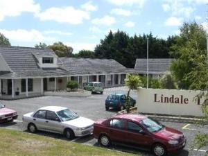 dos autos estacionados en un estacionamiento frente a una biblioteca en Kapiti Lindale Motel and Conference Centre en Paraparaumu