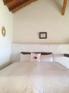 a bedroom with a white bed with a flower on it at Casa ALMA in Hermigua