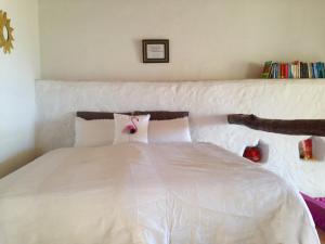 a bedroom with a white bed with a pink bow on it at Casa ALMA in Hermigua