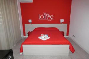 a red bedroom with a bed with a red bedspread at B&B enjoy music in Villa San Giovanni