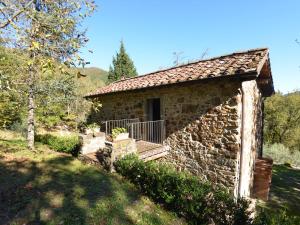 uma antiga casa de pedra com um alpendre num campo em Lovely Cottage in Bagni di Lucca Amidst Fields em Longoio