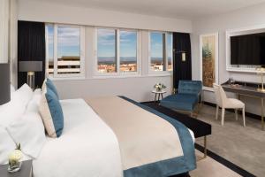 a bedroom with a large white bed and a desk and chairs at Melia Castilla in Madrid