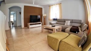 a living room with a couch and a tv at Strandvilla Thiessow in Thiessow