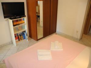 łóżko z różowym prześcieradłem i ręcznikiem w obiekcie DAMIR studio w Crikvenicy