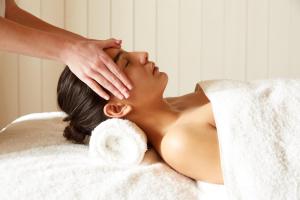 a woman laying on a towel with her hands on her face at St Moritz Hotel and Cowshed Spa in Polzeath