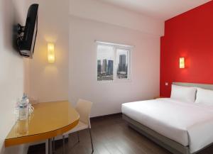 una stanza d'albergo con un letto, un tavolo e una finestra di Amaris Hotel Tendean a Giacarta