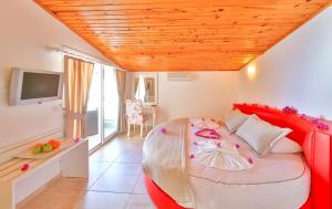 a bedroom with a large bed with a red headboard at Belinda Hotel in Kaş