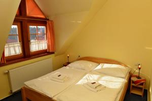 Penzión Schweintaal في Bravačov: غرفة نوم عليها سرير وفوط