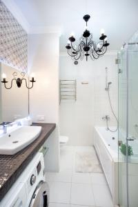 uma casa de banho branca com um lustre e um lavatório em Lotos for You Apartments 2, RED PIANO em Nikolayev