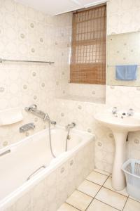 y baño con bañera y lavamanos. en Seabrook 204 Margate RSA, en Margate