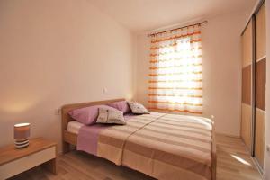 a bedroom with a bed and a window at Apartman Simona in Fažana
