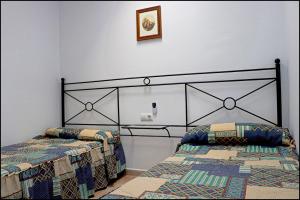 1 dormitorio con 2 camas y una foto en la pared en Apartamento Sol II, en Conil de la Frontera